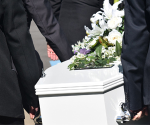 hommes en costume portant un cercueil