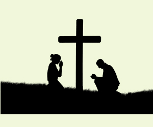 2 personnes prient autour de la croix